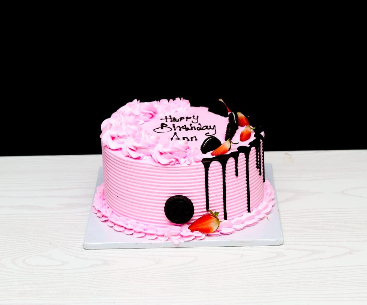 Pink ridged buttercream cake with dark chocolate drip, oreos and strawberries
