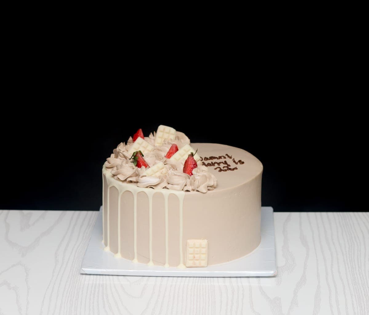Cream cake with white chocolate drip, fresh strawberries and white chocolate bars