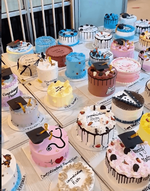 Dozens of finished graduation cakes lined up on the counter at The Hive Pastries