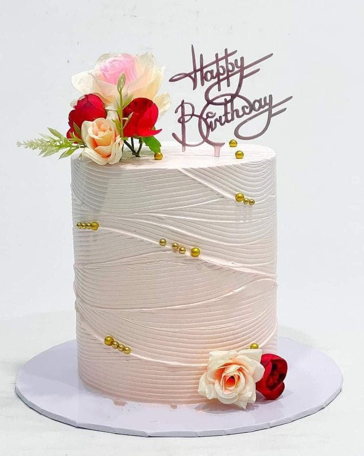 Tall blush pink cake with gold pearls, fresh roses and a mirror topper